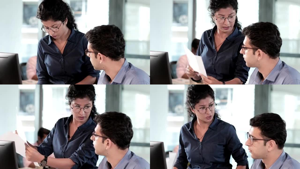 一位戴眼镜的年轻女老板对坐在电脑屏幕前的年轻男员工或下属大骂大叫