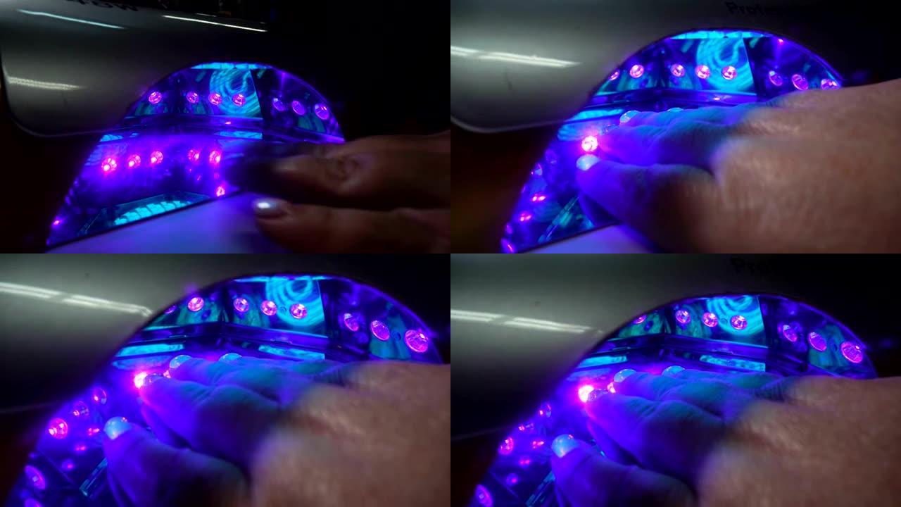 指甲用紫外线灯的手。水疗护理。指甲处理，用紫外线灯干燥漆