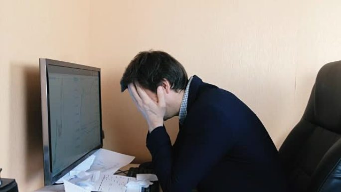 困惑的人在电脑前工作。绝望的眼泪纸，然后扔出去。