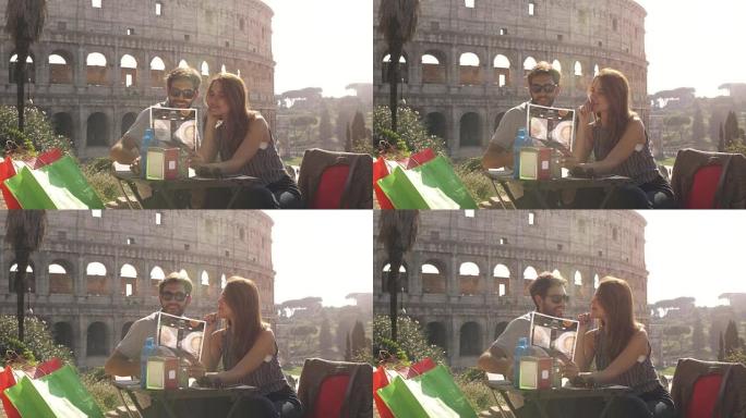 快乐的年轻夫妇游客阅读菜单选择食物和饮料日落时坐在罗马罗马斗兽场前的酒吧餐厅准备点菜