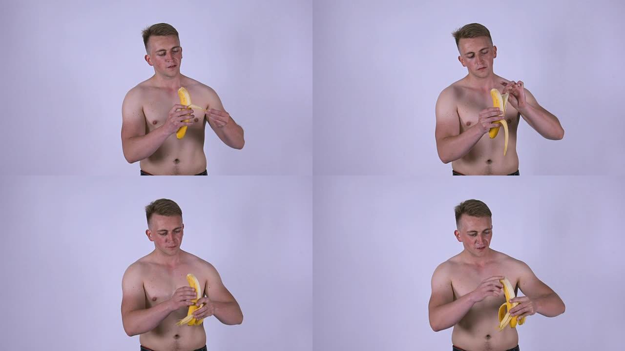 一个年轻性感的男人正在吃香蕉。