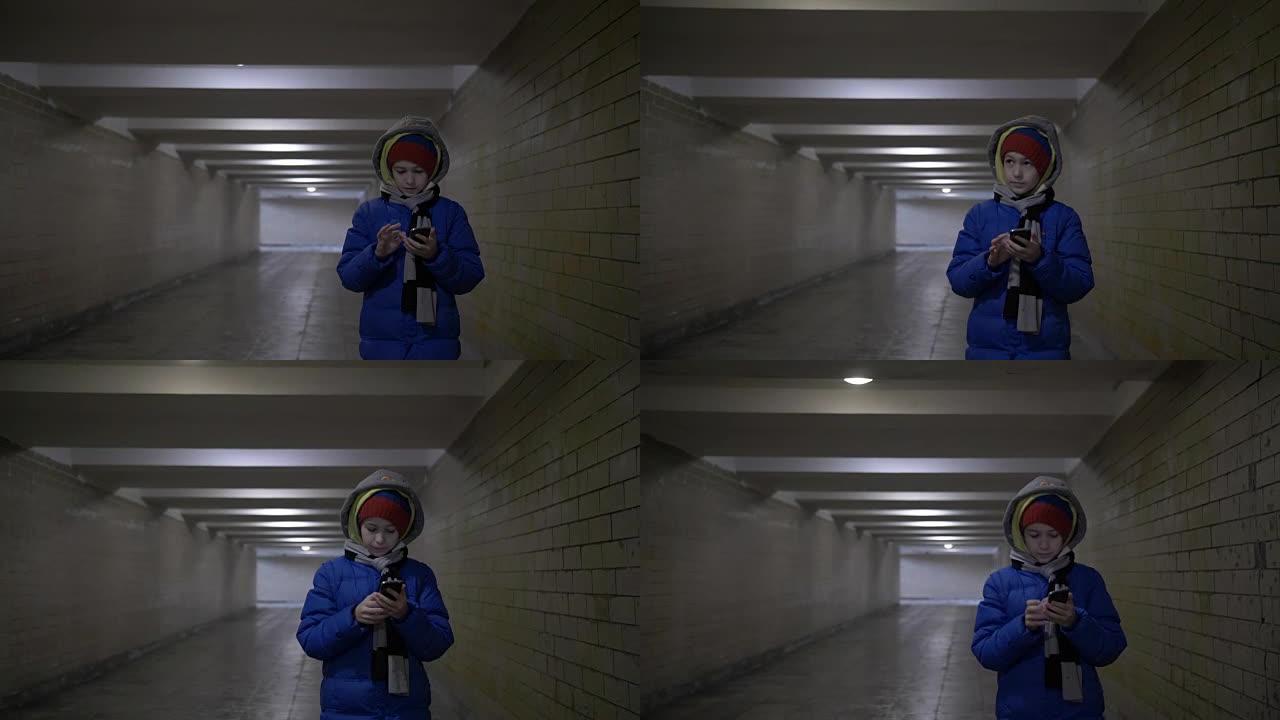 男孩在冬天用电话走隧道
