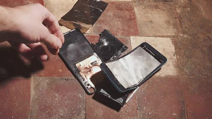 锤子撞击智能手机，破碎的触摸屏玻璃慢动作迅速。碎片碎片。