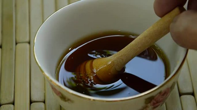 从杯子里手工采摘木制蜂蜜勺
