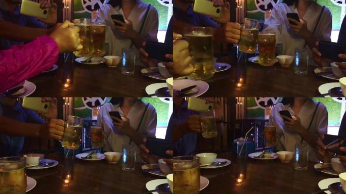 亚洲朋友与含酒精的啤酒饮料聚会，年轻人在酒吧享用鸡尾酒。