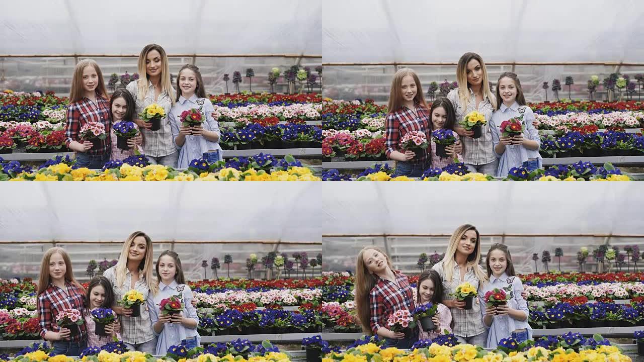 微笑的四个女孩的肖像同步伸展花盆到相机