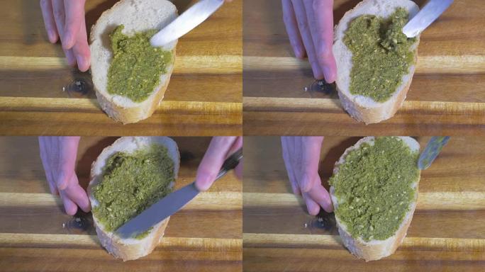 在面包上撒上绿色香蒜酱