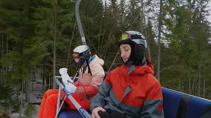 滑雪缆车上的滑雪者和滑雪者。