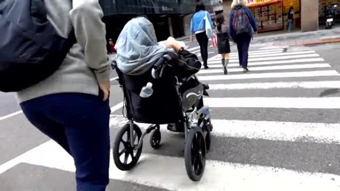 年轻女子推着轮椅过马路