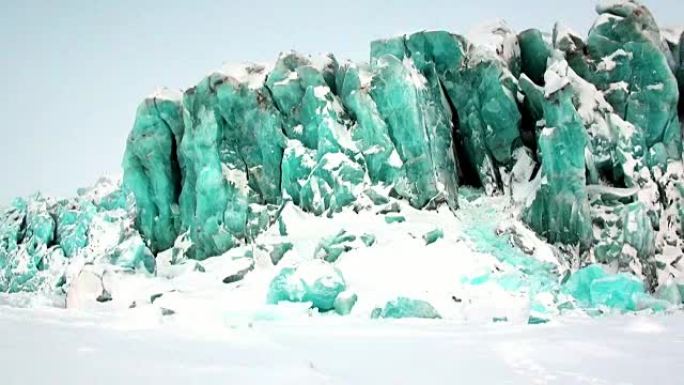 北极积雪背景上美丽独特的绿松石色冰川。