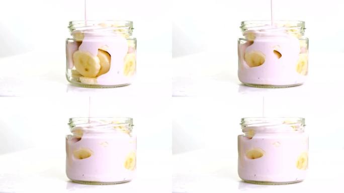 白色背景的罐子里有香蕉的新鲜水果酸奶。全高清