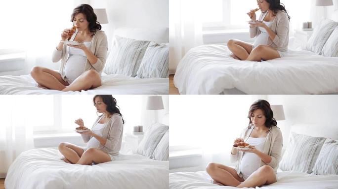 孕妇在家床上吃羊角面包