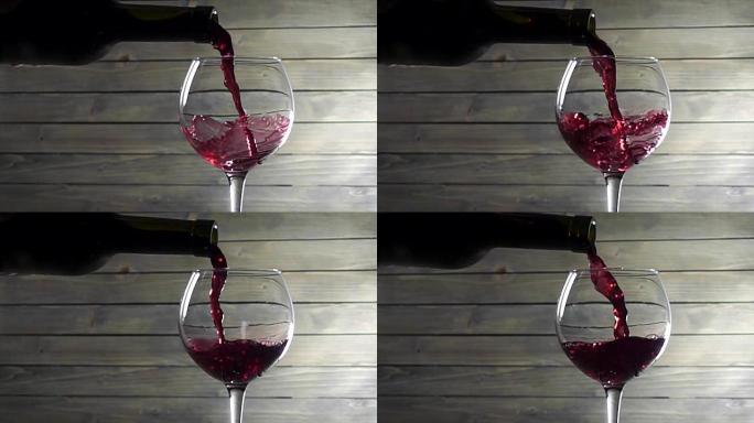 将红酒倒入木制背景的玻璃杯中。慢动作