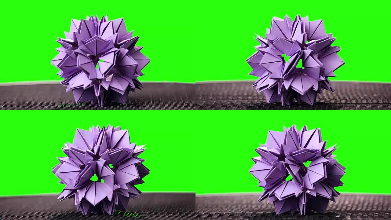 绿色屏幕上的紫罗兰折纸花。