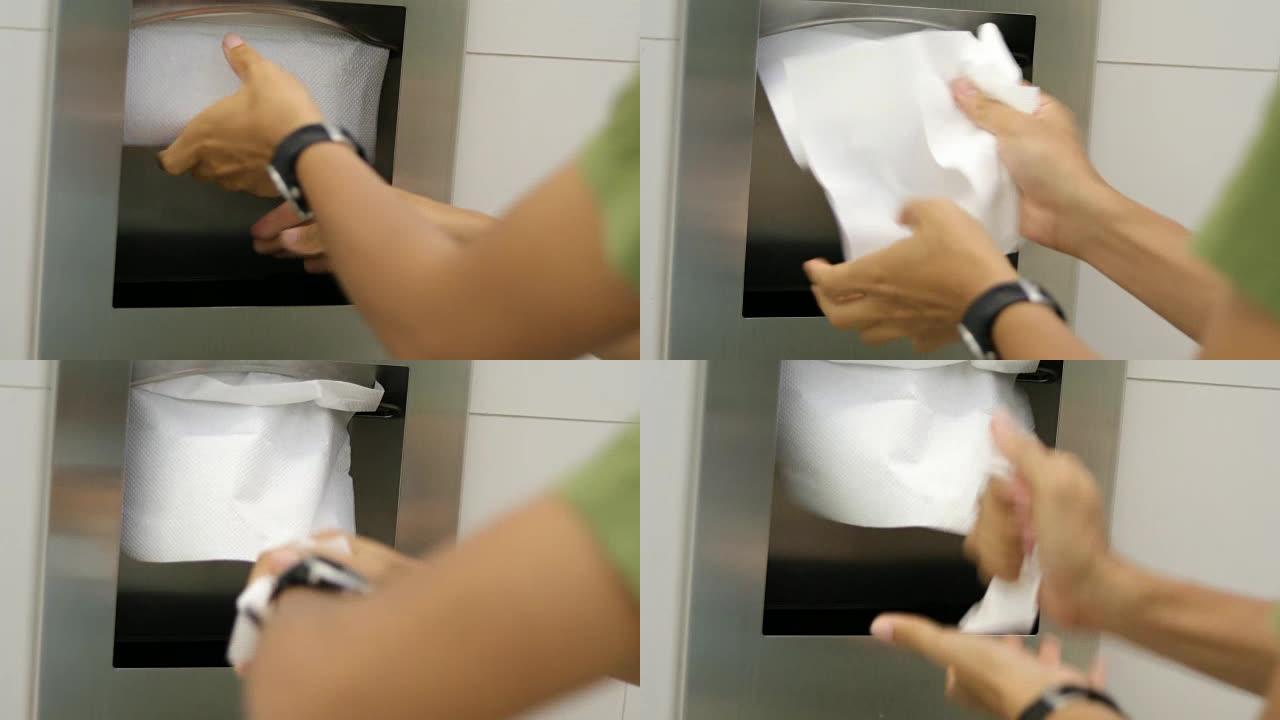 男人在用液体肥皂洗手后用纸巾擦手。
