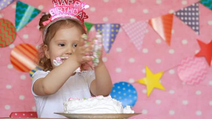 蛋糕里孩子的脏手。生日和派对。有趣的女孩用甜点舔她的手指