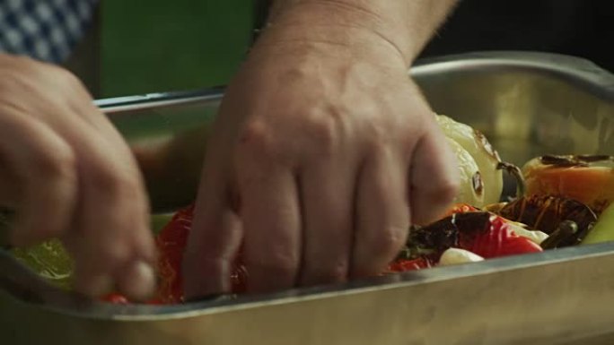 一位厨师正在准备不同品种的辣椒，以便在烤箱中烘烤。