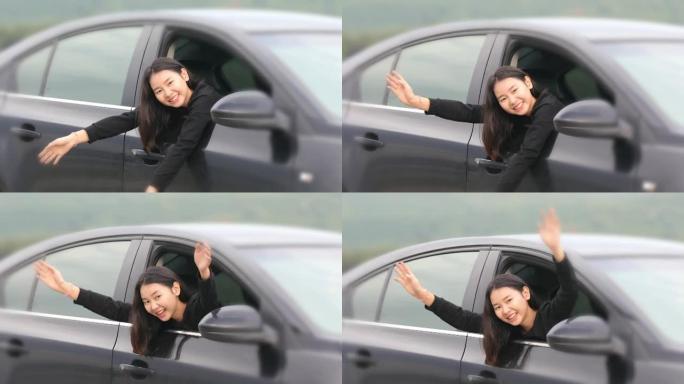 美丽的亚洲女人微笑着享受着。开车上路旅行