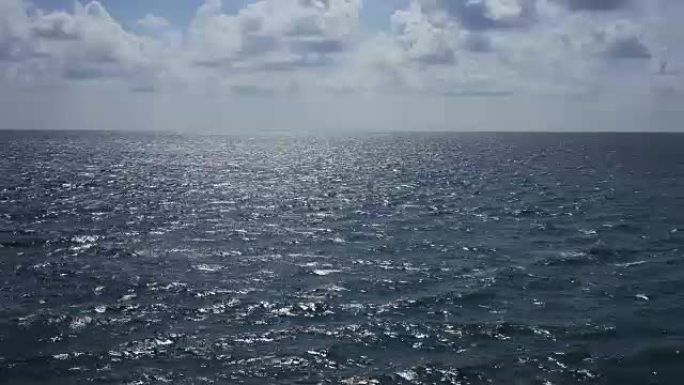 晴朗的日子里的大海，从移动的船上可以看到。美丽的云朵漂浮着。