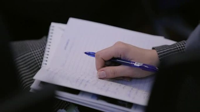 女人在会议或培训的笔记本上做笔记