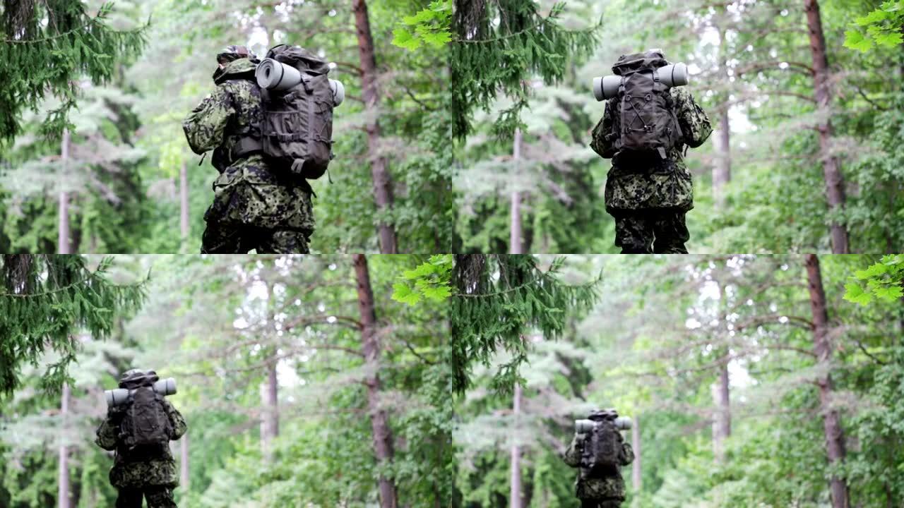 年轻的士兵，护林员或猎人背着背包在森林里行走