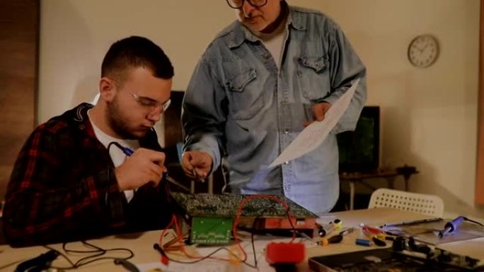 两个男工程师试图通过焊接来修复电路...