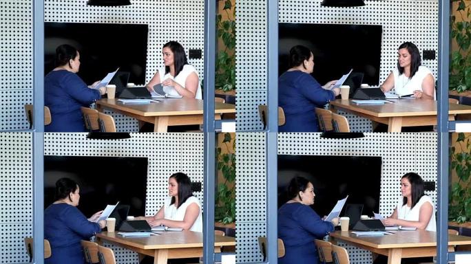 两名毛利女雇员在商务会议上与文书工作和文件