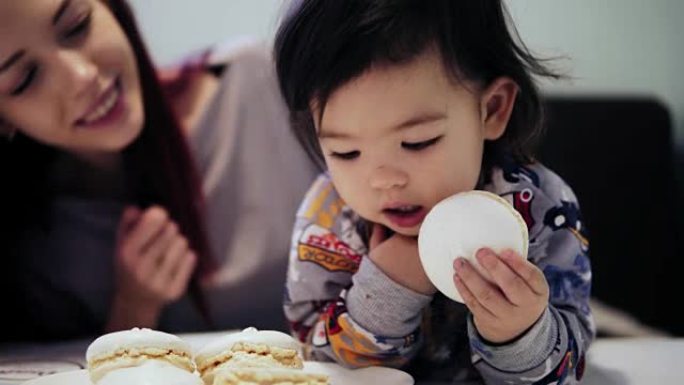 An adorable cute asian toddler boy enjoys eating m
