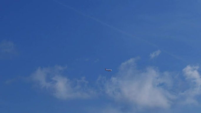 客机在云层上方的蓝天上飞得很远