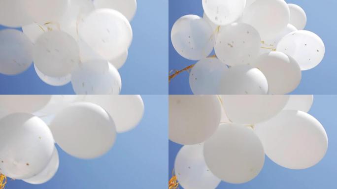 蓝天中膨胀的白色氦气球
