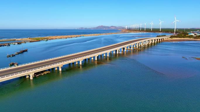 航拍美丽海岸线跨海大桥风力发电