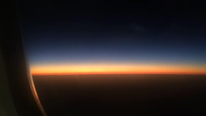 穿过飞机窗户的美丽日落