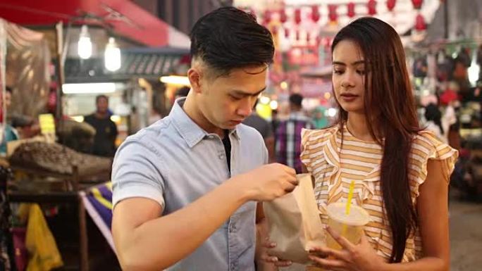 夫妇在Jalan Petaling市场吃街头食品