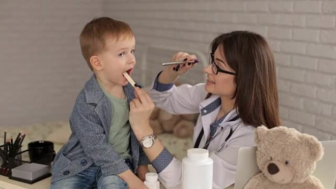 儿童医生检查生病男孩的喉咙。
