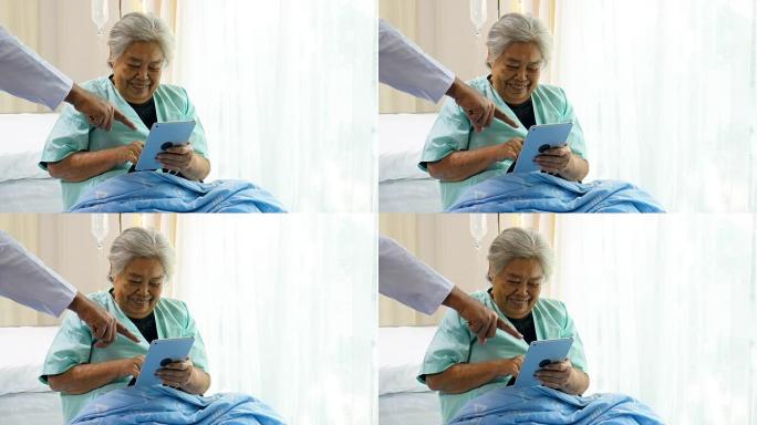 亚洲男性医生使用数字平板电脑与医院病房的高级患者女性讨论