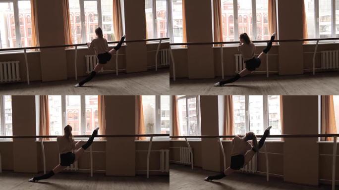 灵活的年轻女舞者在工作室里伸展双腿