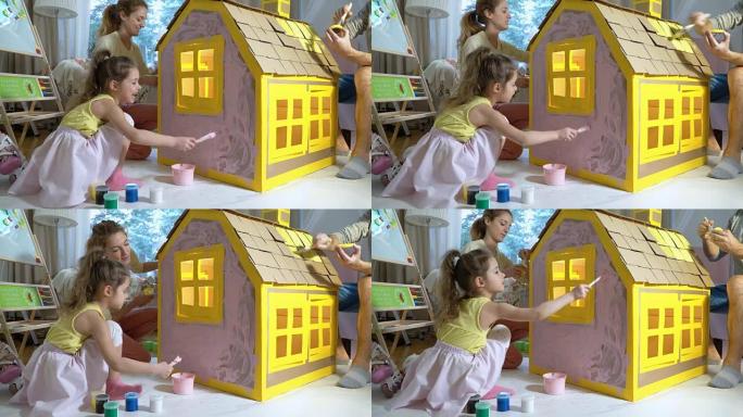 Young family with child building and painting toy 