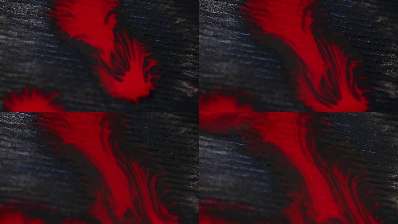 用微距镜头在黑色背景上滴下红色水滴