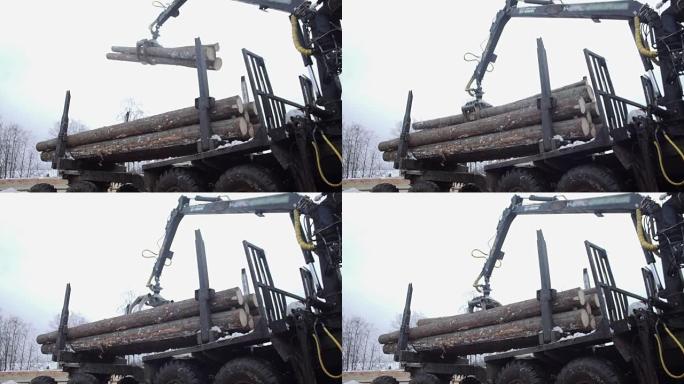 重型臂装载机在锯木厂从重型卡车上卸下原木