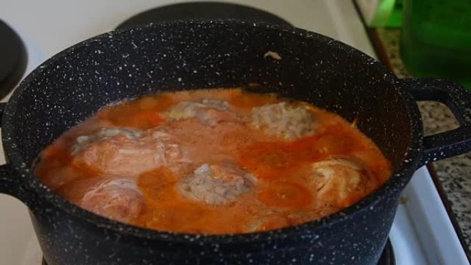 煮沸的酱汁肉丸站在炉子上，放在锅里，盖上盖子。