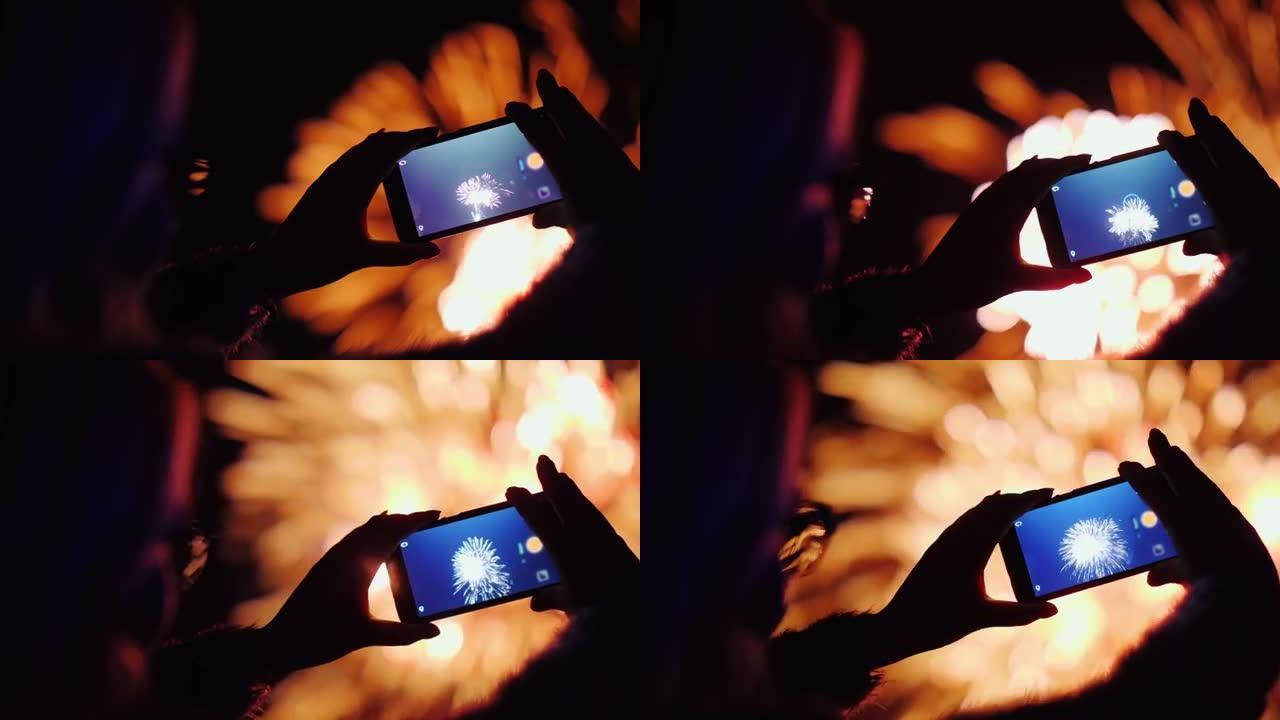一个女人用智能手机拍摄烟花。灯光在她的眼镜上反射得很漂亮。4k 10位视频