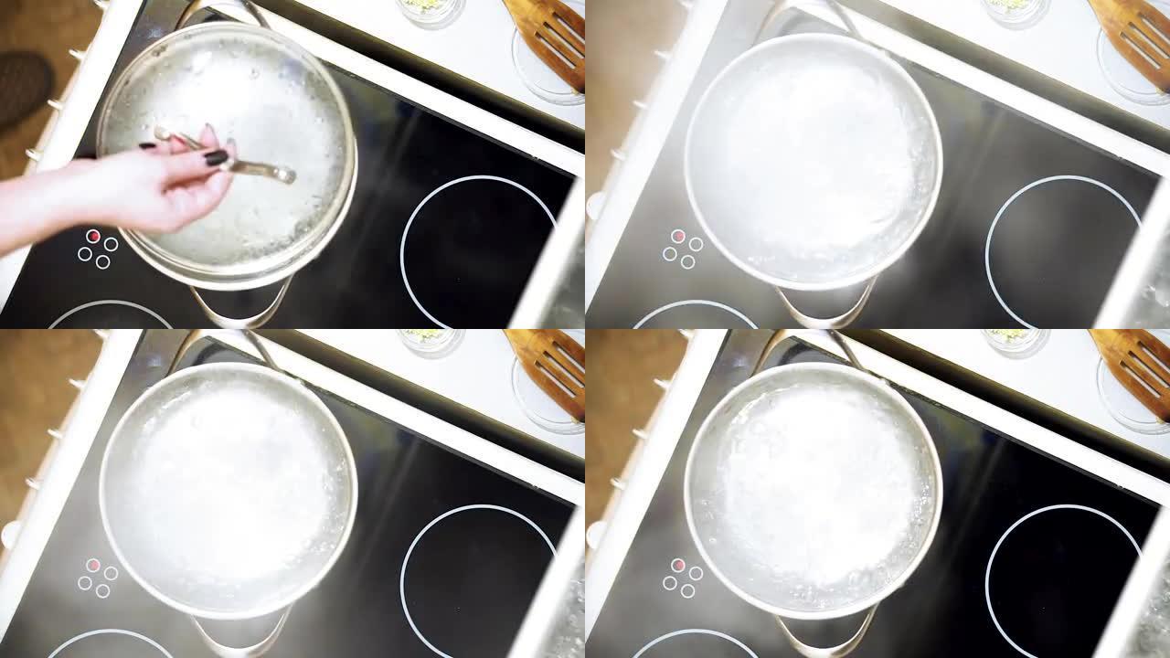 厨师在电炉上用开水打开锅。