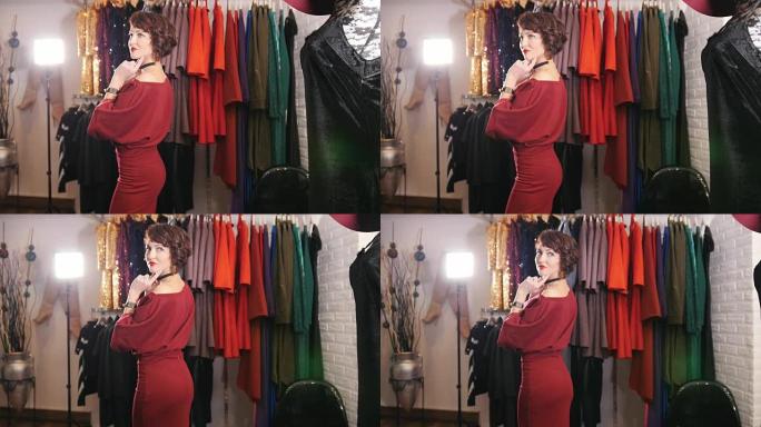美丽的红色晚礼服女性在精品陈列室为摄影师摆姿势