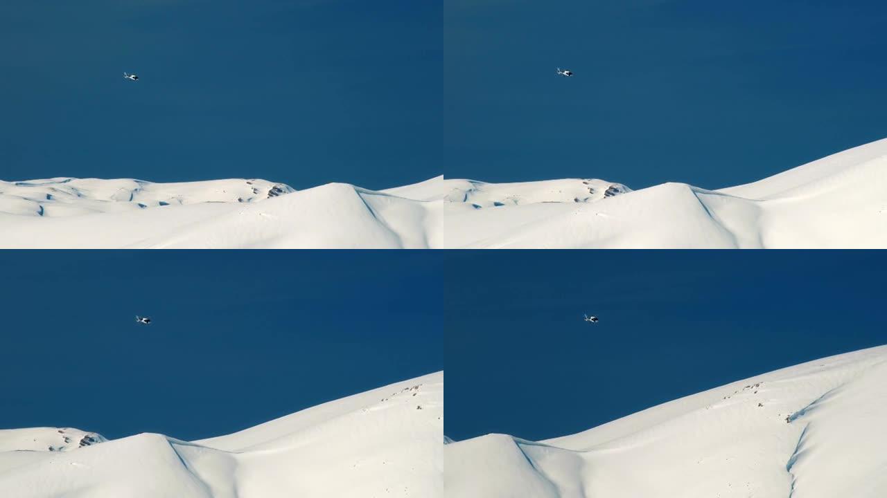 直升机在雪山的背景下飞行