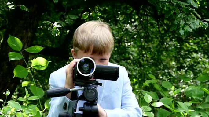 小男孩在绿色公园慢动作中观看有关自然的视频拍摄电影。