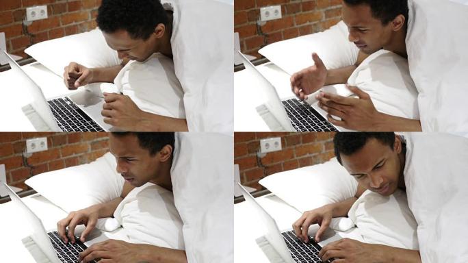 沮丧的非洲男子对笔记本电脑的损失做出反应，躺在肚子上