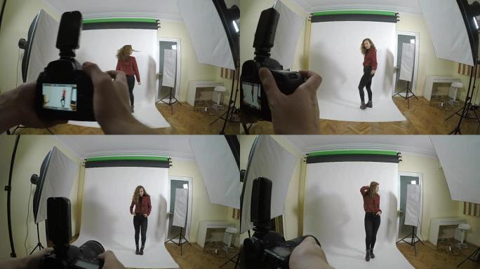 一位年轻摄影师用数码相机拍摄专业照片的观点，为白色背景工作室中的女性进行时尚社论