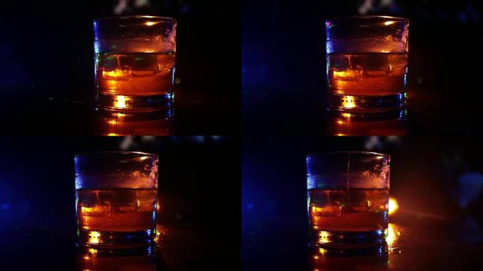 选择性聚焦纯威士忌，威士忌杯内有冰块，在暗雾背景酒精饮料概念。特写。滑块镜头