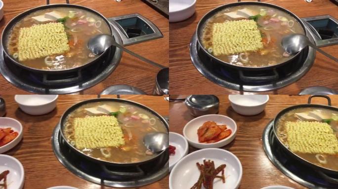 用海鲜勺倒入热汤。正宗韩国料理
