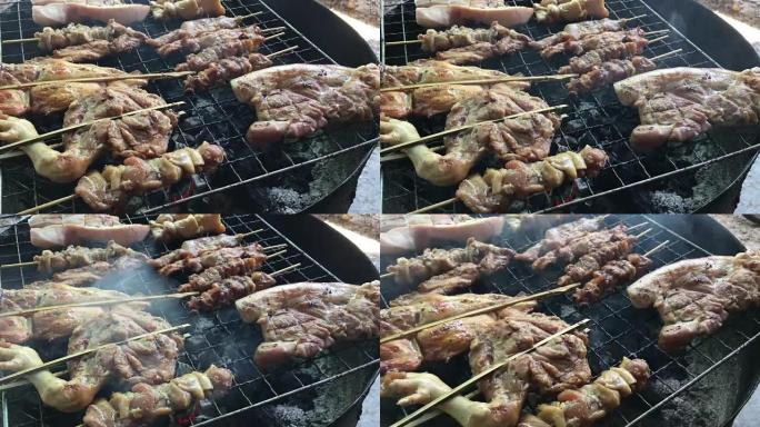 泰国街头食品: 炭烤烤鸡，火炉上的猪肉用烟半切油罐。泰式食物。泰语烧烤或泰语中的 “Moo Ping